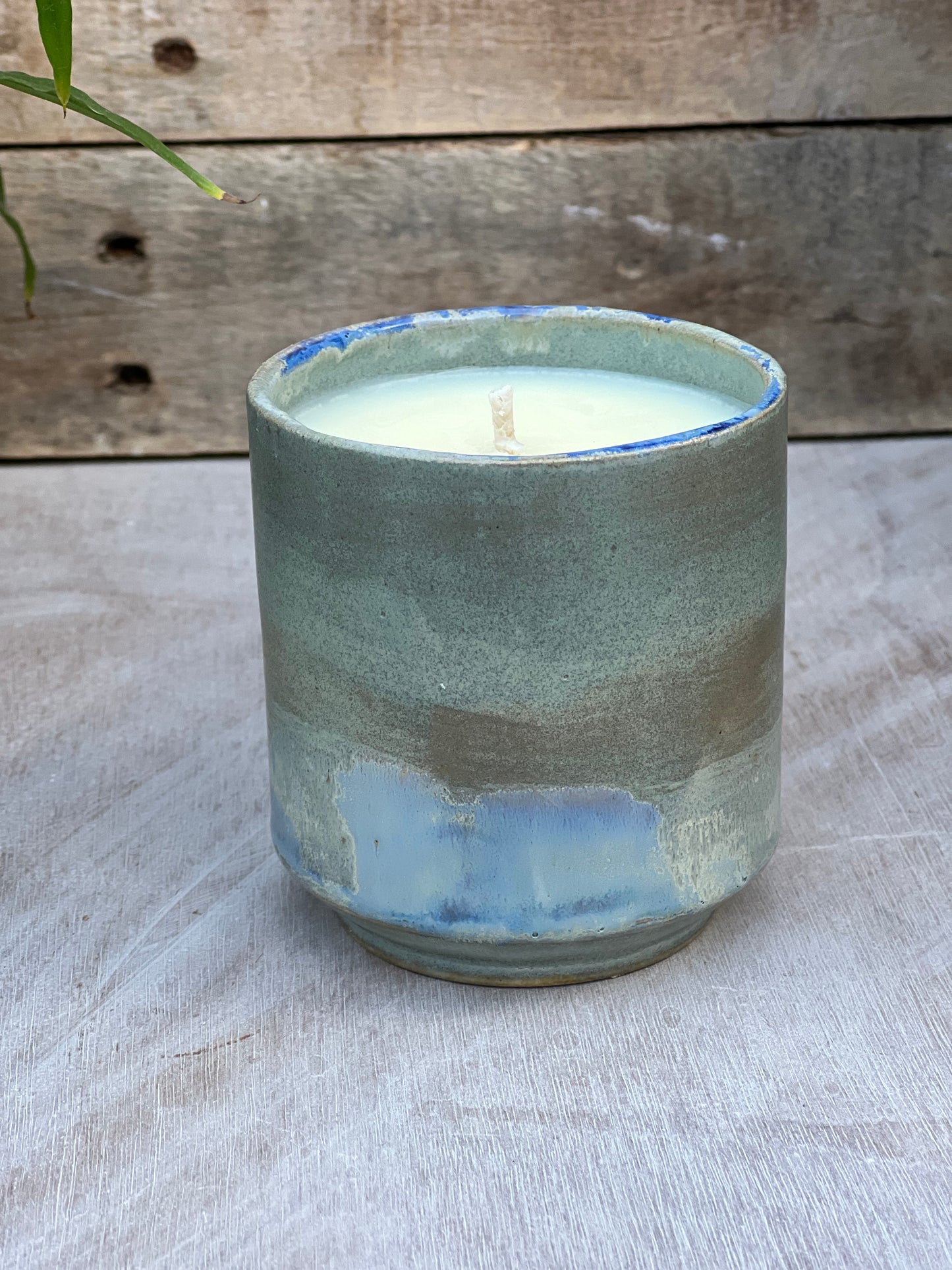 Ceramic candle pot mini planter with blue glazes on a wooden surface