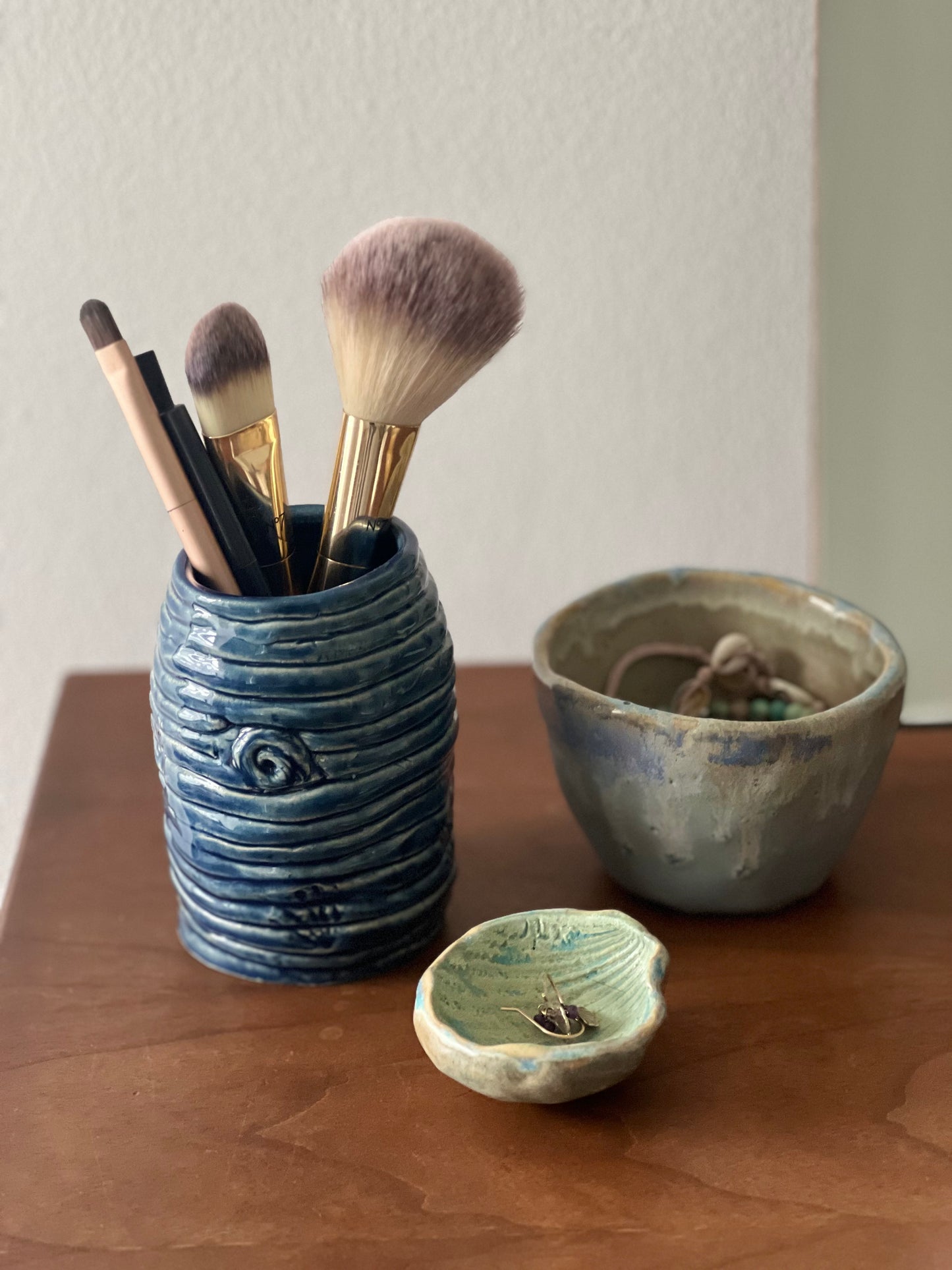 Ceramic pot used as a holder for makeup brushes on dressing table as
