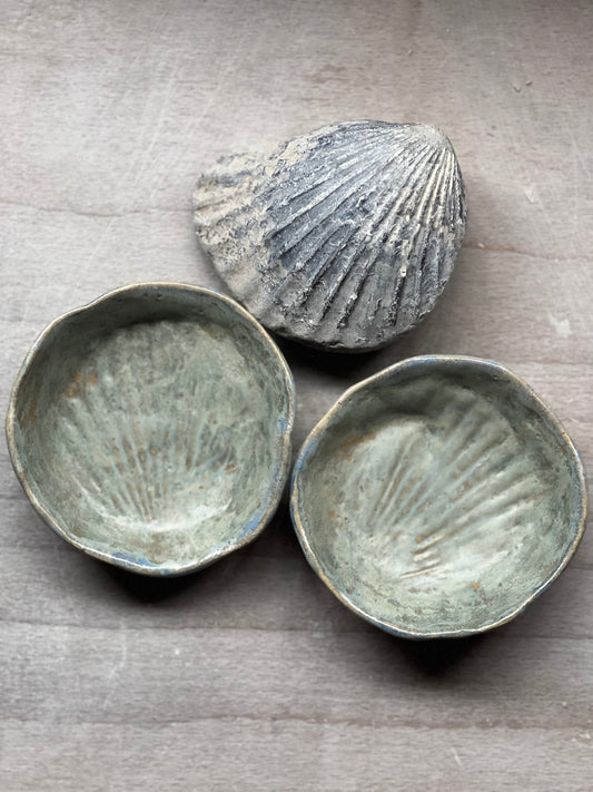 Two ceramic shell-shaped bowls and a shell fossil